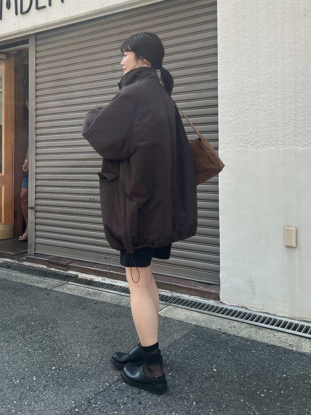 ブラウン系のダウンジャケット/コートを着用したレディースの夏コーディネートの2枚目の写真