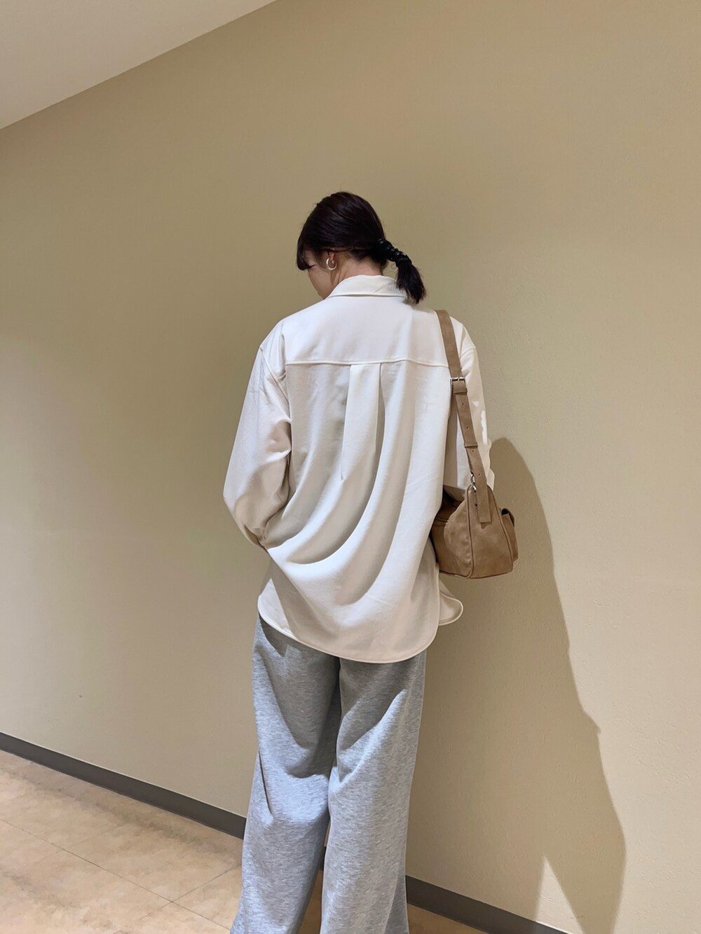 イエロー系のショルダーバッグ、ホワイト系のシャツ/ブラウス、グレー系のその他パンツを着用したレディースの冬コーディネートの2枚目の写真