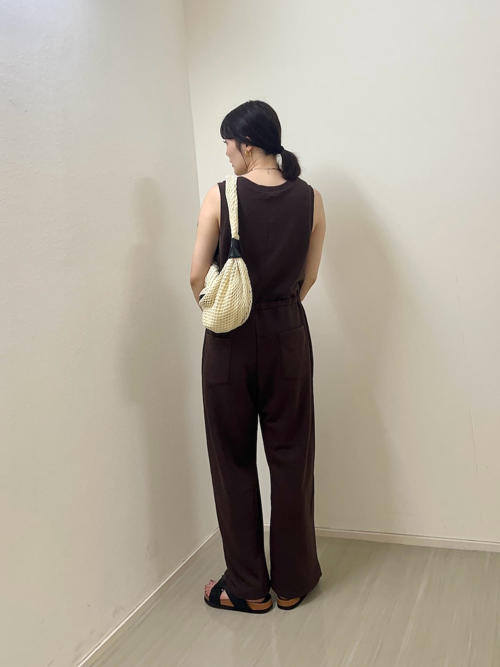 ブラウン系のその他パンツ、ホワイト系のショルダーバッグ、ブラック系のサンダルを着用したレディースの夏コーディネートの2枚目の写真