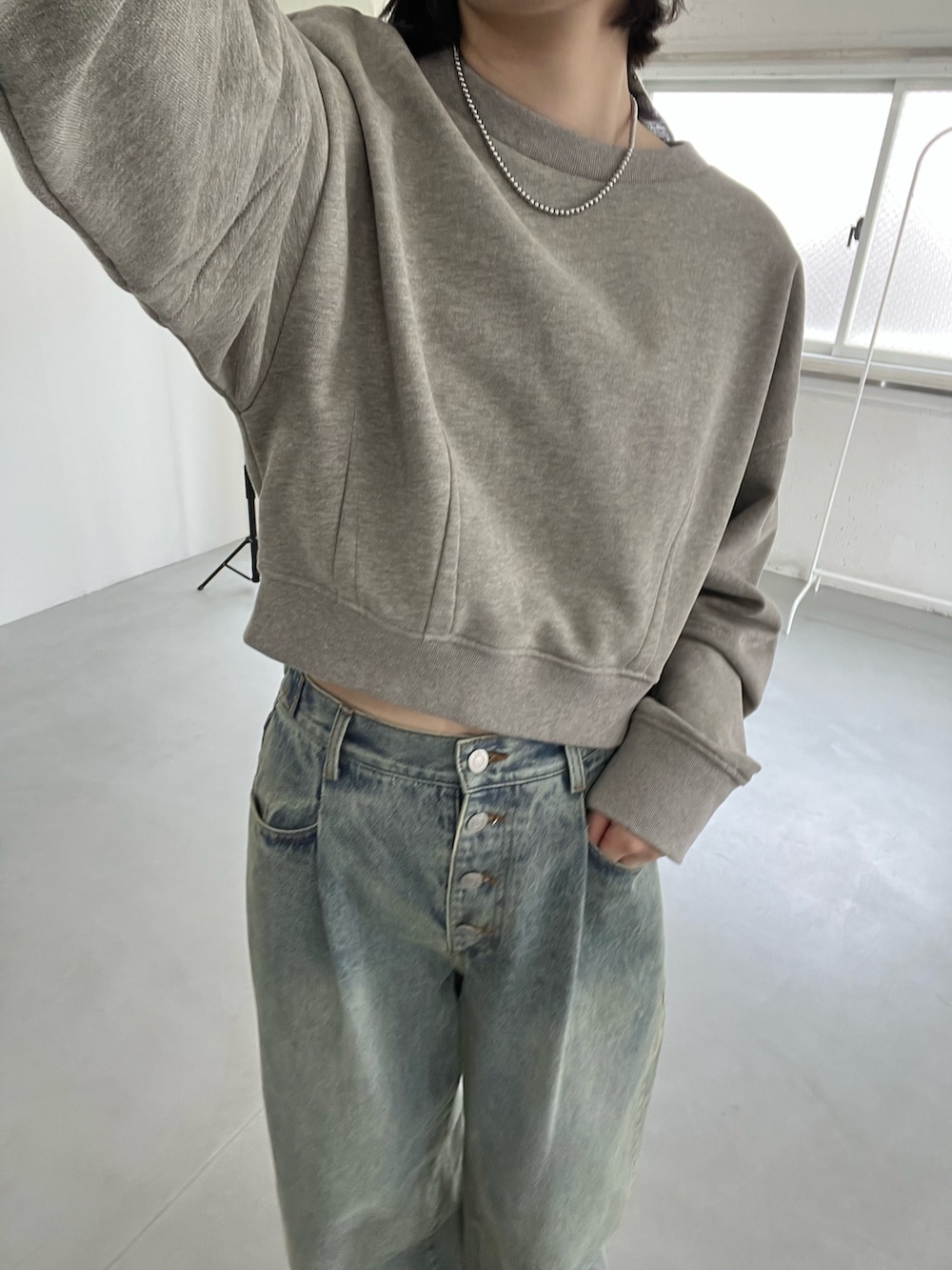 ベージュ系のスウェット、ブルー系のデニムパンツを着用したレディースの冬コーディネートの4枚目の写真