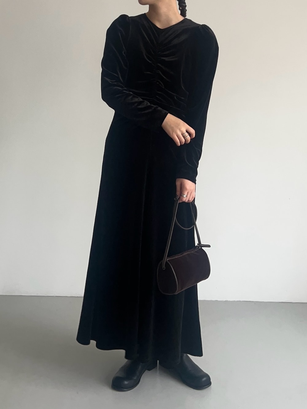 ブラック系のワンピース、ブラウン系のショルダーバッグ、ブラック系のブーツを着用したレディースの秋コーディネートの2枚目の写真