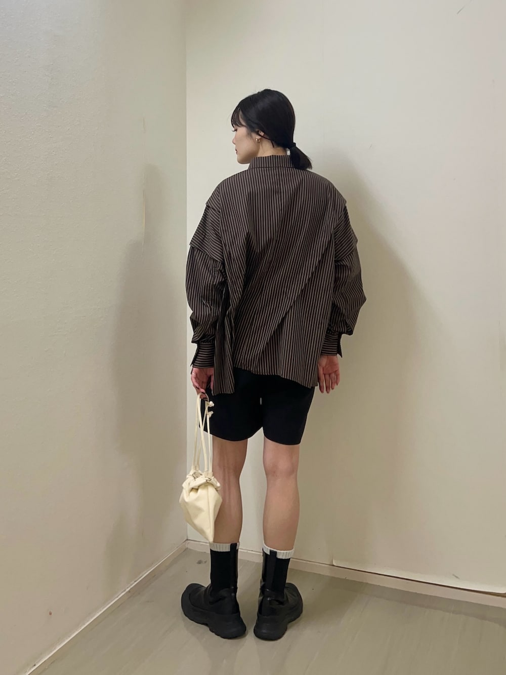 ブラウン系のシャツ/ブラウス、ホワイト系のショルダーバッグを着用したレディースの春コーディネートの2枚目の写真