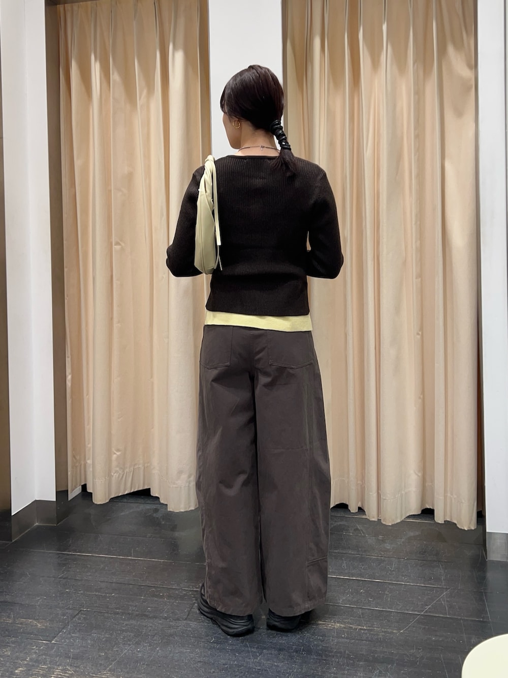 ブラウン系のニット/セーター、ホワイト系のハンドバッグ、グレー系のその他パンツを着用したレディースの冬コーディネートの2枚目の写真