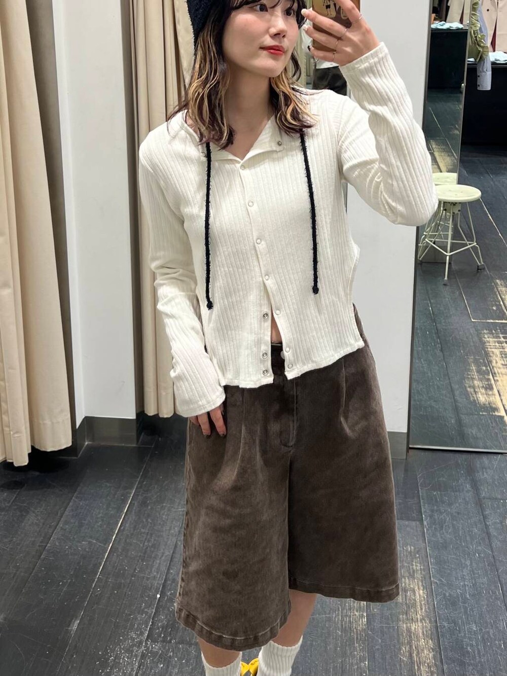 ブラウン系のその他パンツ、ホワイト系のニット/セーター、ブラック系のニットキャップ/ビーニーを着用したレディースの春コーディネートの2枚目の写真