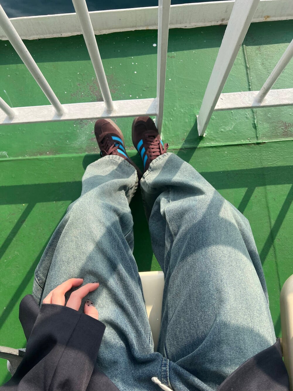 グレー系のその他アウター、ブラック系のボストンバッグ、ブルー系のデニムパンツを着用したレディースの冬コーディネートの2枚目の写真