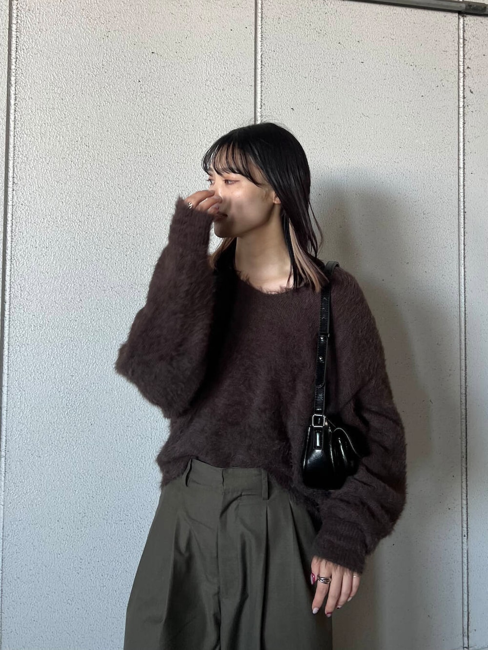 シルバー系のブーツ、グリーン系のその他パンツ、ブラック系のショルダーバッグを着用したレディースの冬コーディネートの2枚目の写真