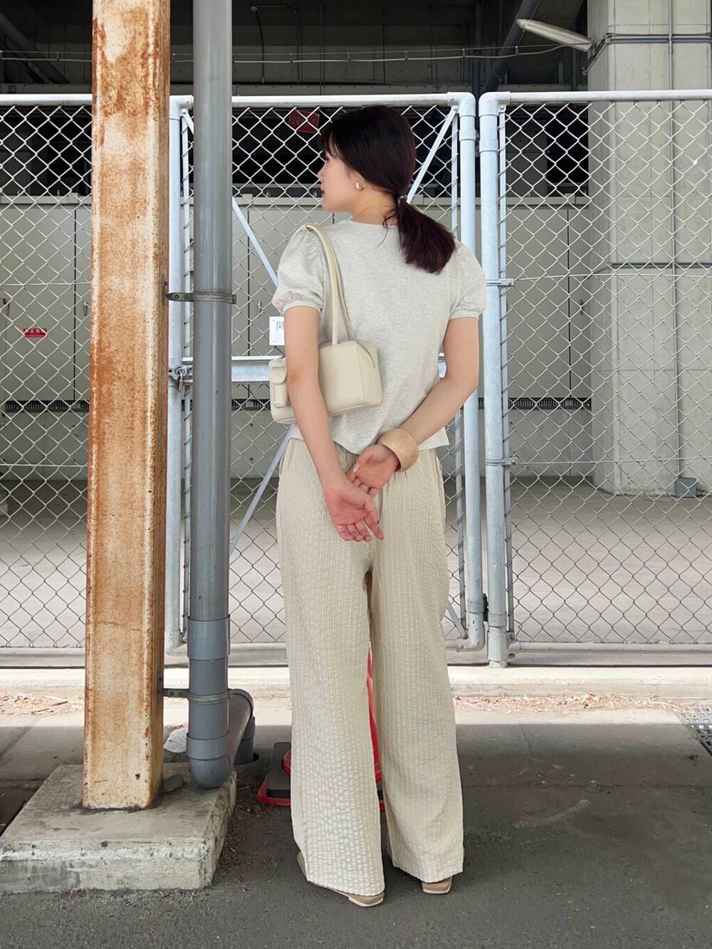 ホワイト系のショルダーバッグ、ベージュ系のその他シューズ、ベージュ系のTシャツ/カットソーを着用したレディースの春コーディネートの2枚目の写真