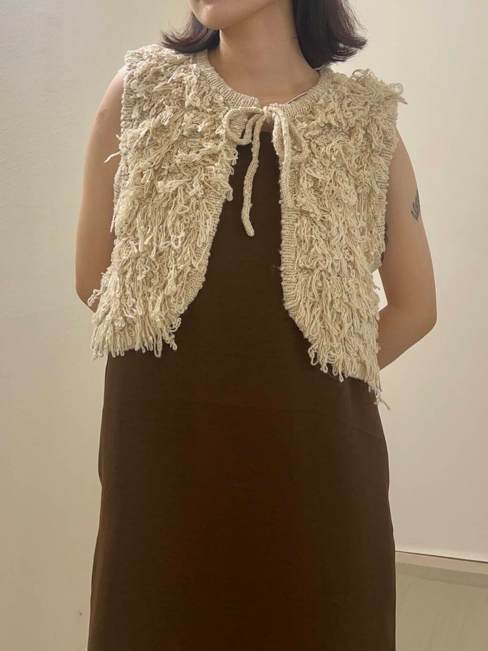 ブラウン系のワンピース、ベージュ系のベストを着用したレディースの夏コーディネートの3枚目の写真