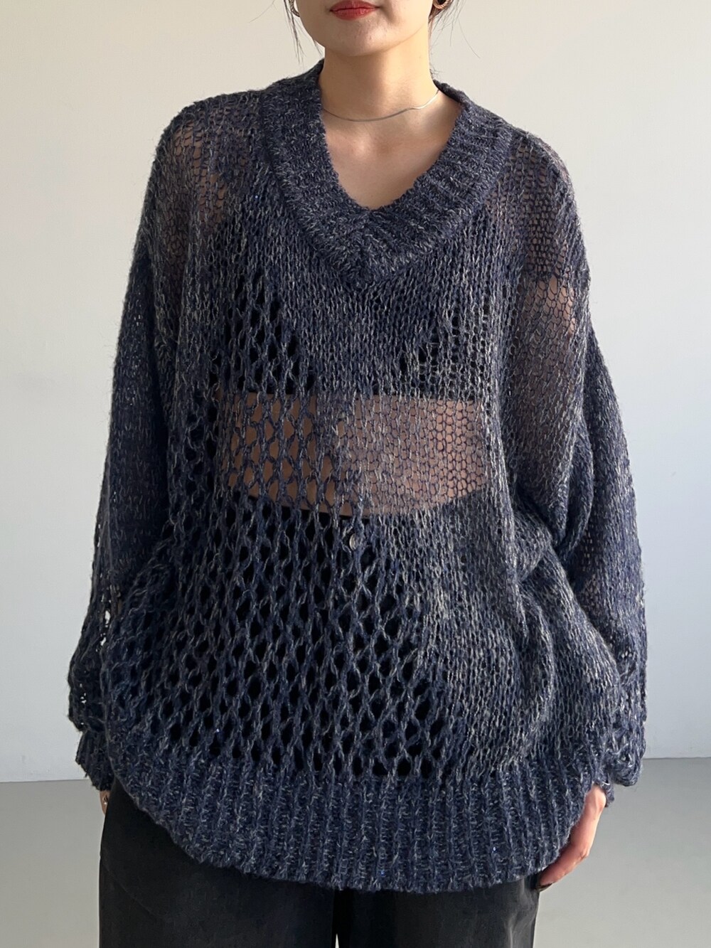 ブルー系のニット/セーター、ブラック系のデニムパンツ、ブラック系のスニーカーを着用したレディースの秋コーディネートの3枚目の写真