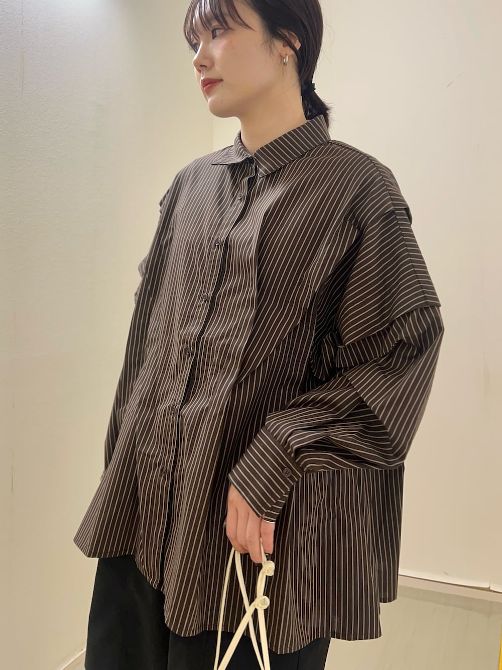 ブラウン系のシャツ/ブラウス、ホワイト系のショルダーバッグを着用したレディースの春コーディネートの3枚目の写真