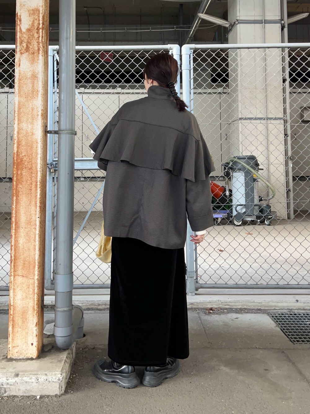 グレー系のその他アウター、ブラック系のスカート、ブラック系のブーツを着用したレディースの秋コーディネートの2枚目の写真