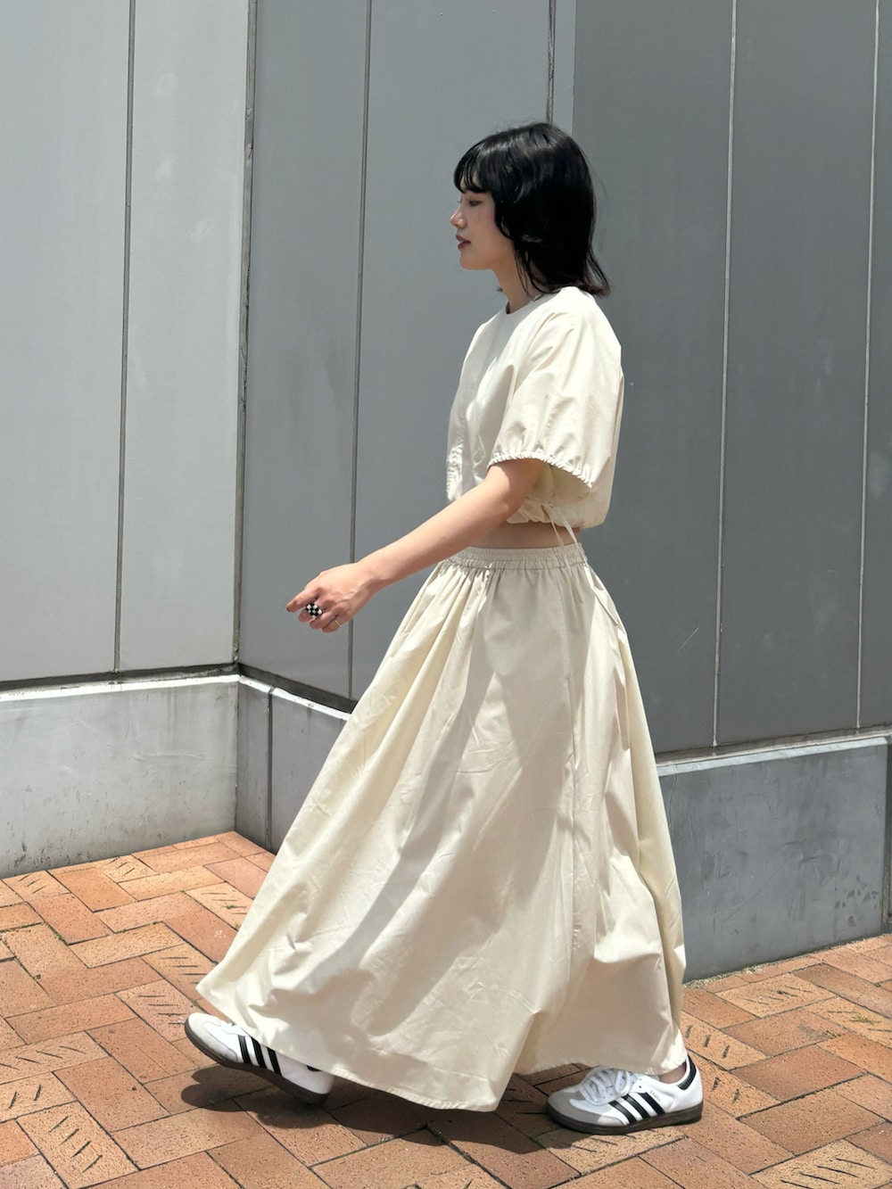 ホワイト系のワンピース、ホワイト系のスニーカーを着用したレディースの夏コーディネートの3枚目の写真