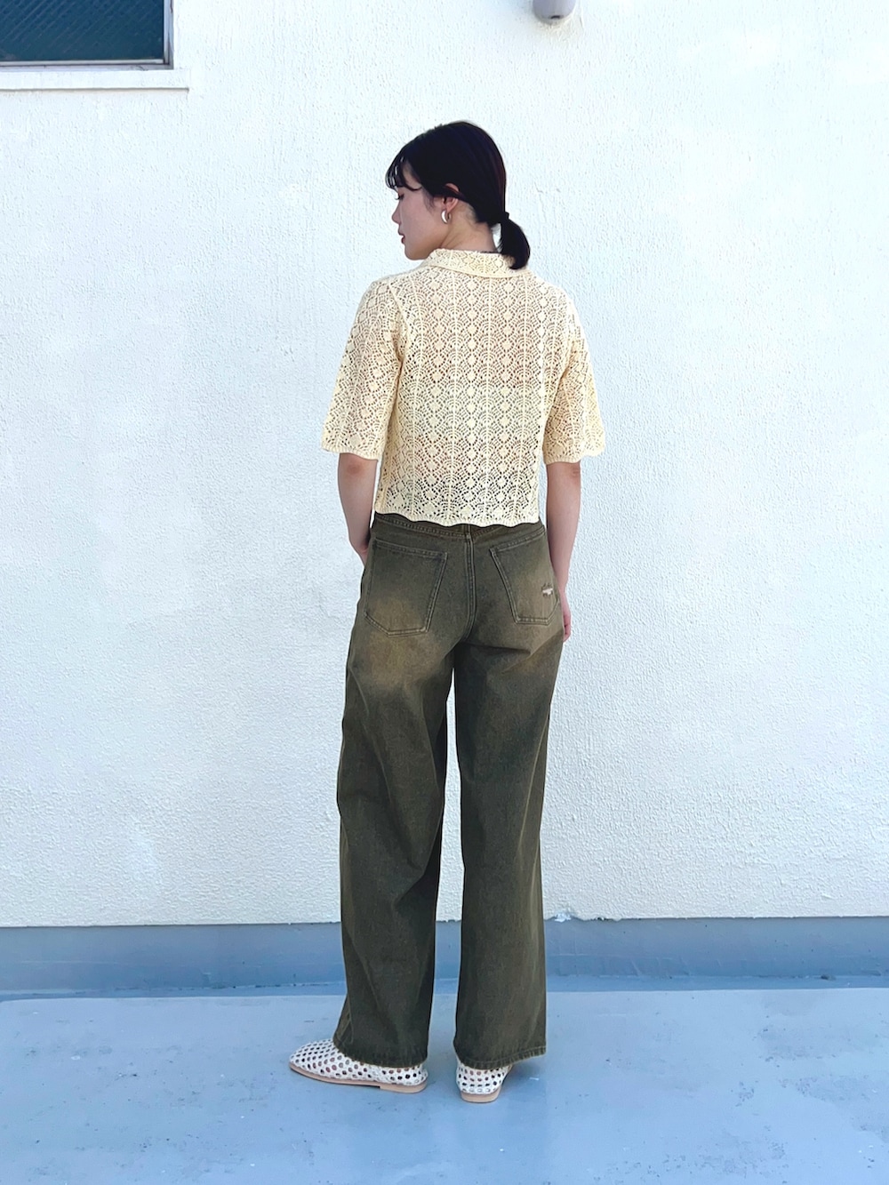 ホワイト系のニット/セーター、グリーン系のデニムパンツ、ホワイト系のサンダルを着用したレディースの夏コーディネートの2枚目の写真