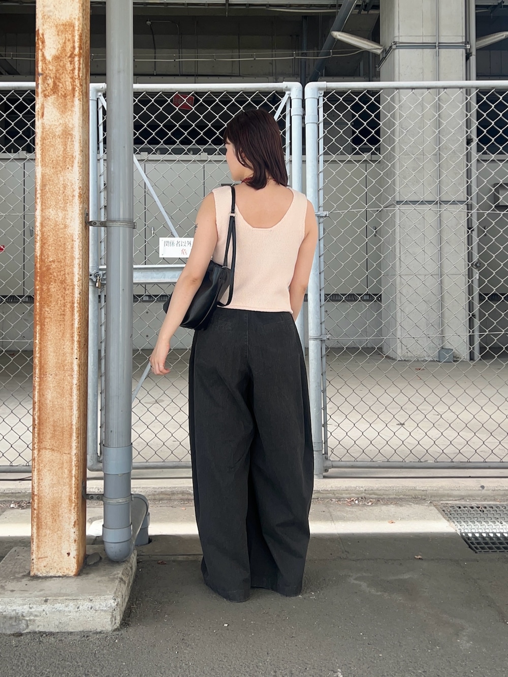 ピンク系のベスト、グレー系のその他パンツ、ブラック系のショルダーバッグを着用したレディースの夏コーディネートの2枚目の写真