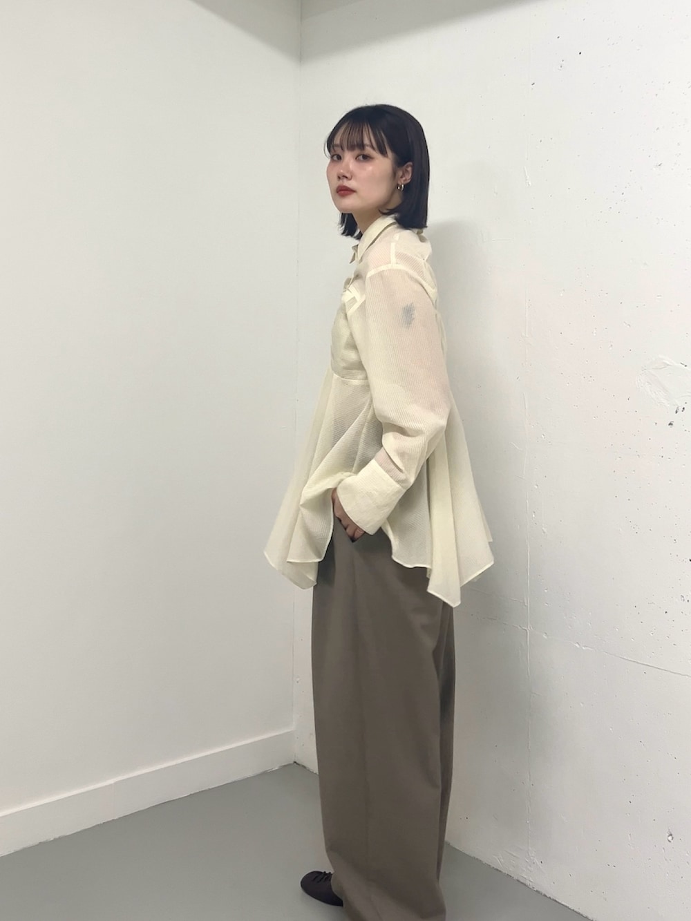 ホワイト系のシャツ/ブラウス、グレー系のその他パンツ、ブラック系のその他シューズを着用したレディースの春コーディネートの2枚目の写真