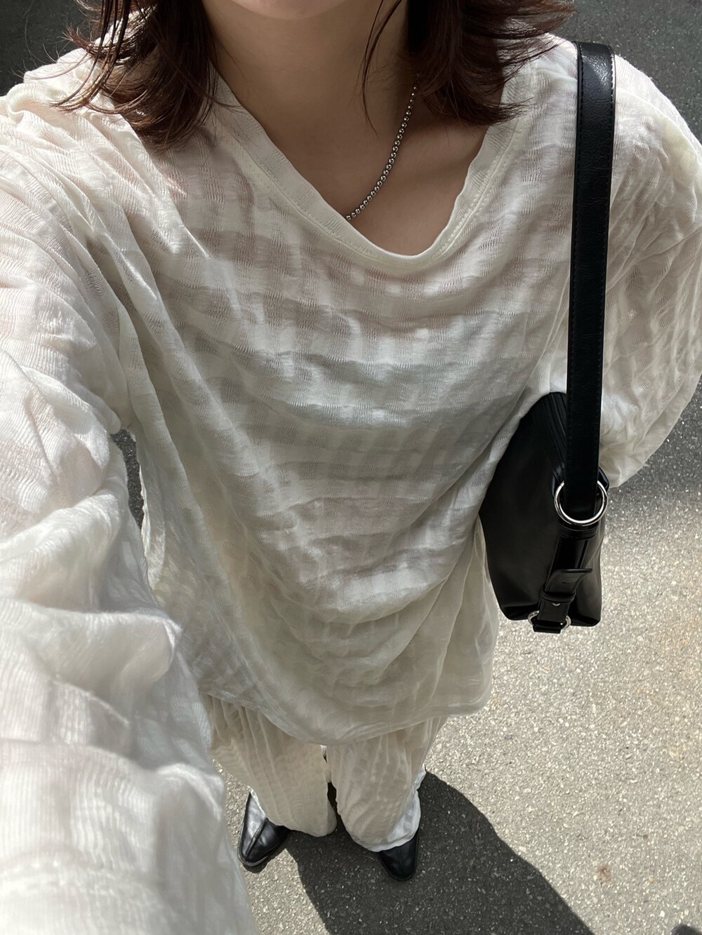 ホワイト系のTシャツ/カットソー、ホワイト系のその他パンツ、ブラック系のショルダーバッグを着用したレディースの秋コーディネートの2枚目の写真