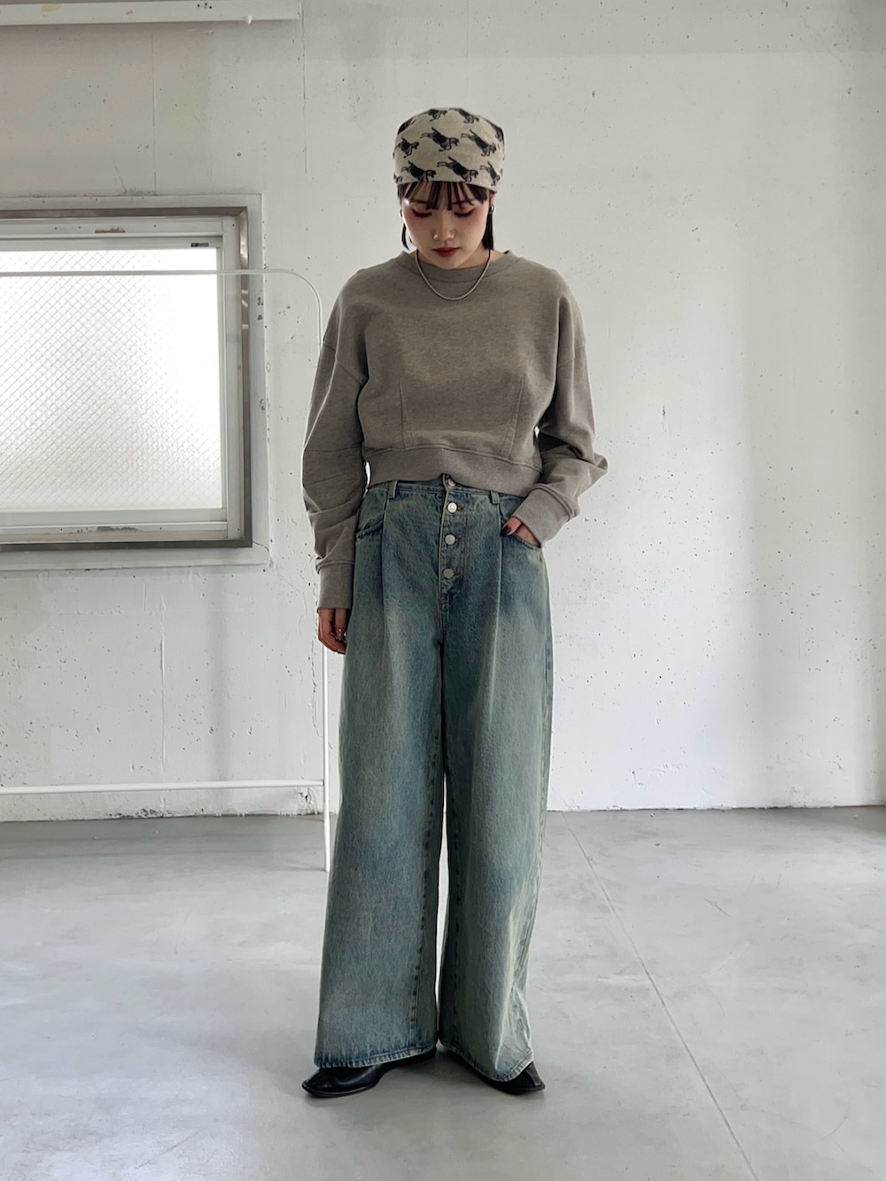 ベージュ系のスウェット、ブルー系のデニムパンツを着用したレディースの冬コーディネートの2枚目の写真