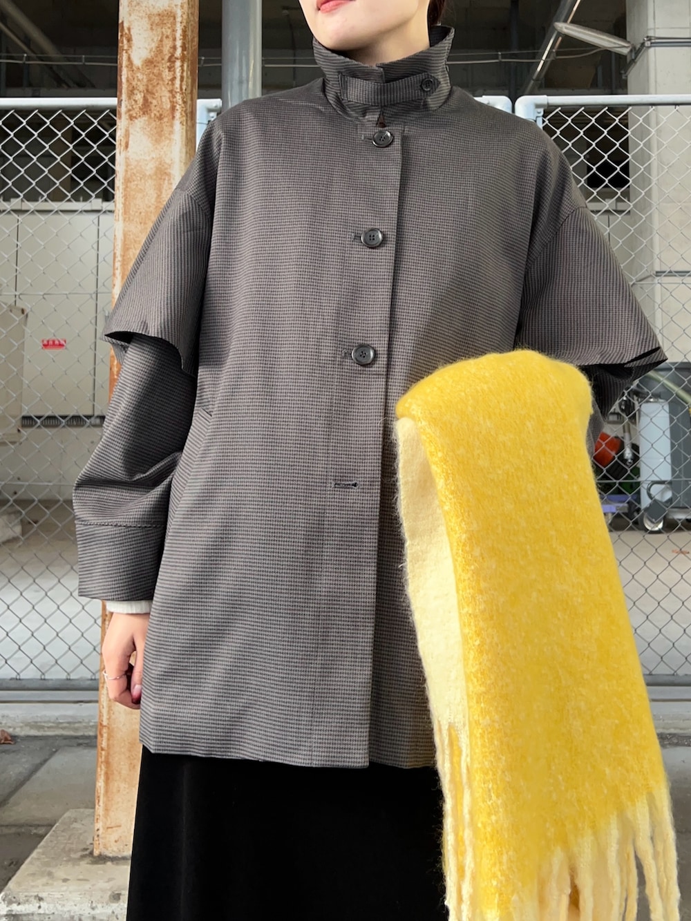 グレー系のその他アウター、ブラック系のスカート、ブラック系のブーツを着用したレディースの秋コーディネートの3枚目の写真