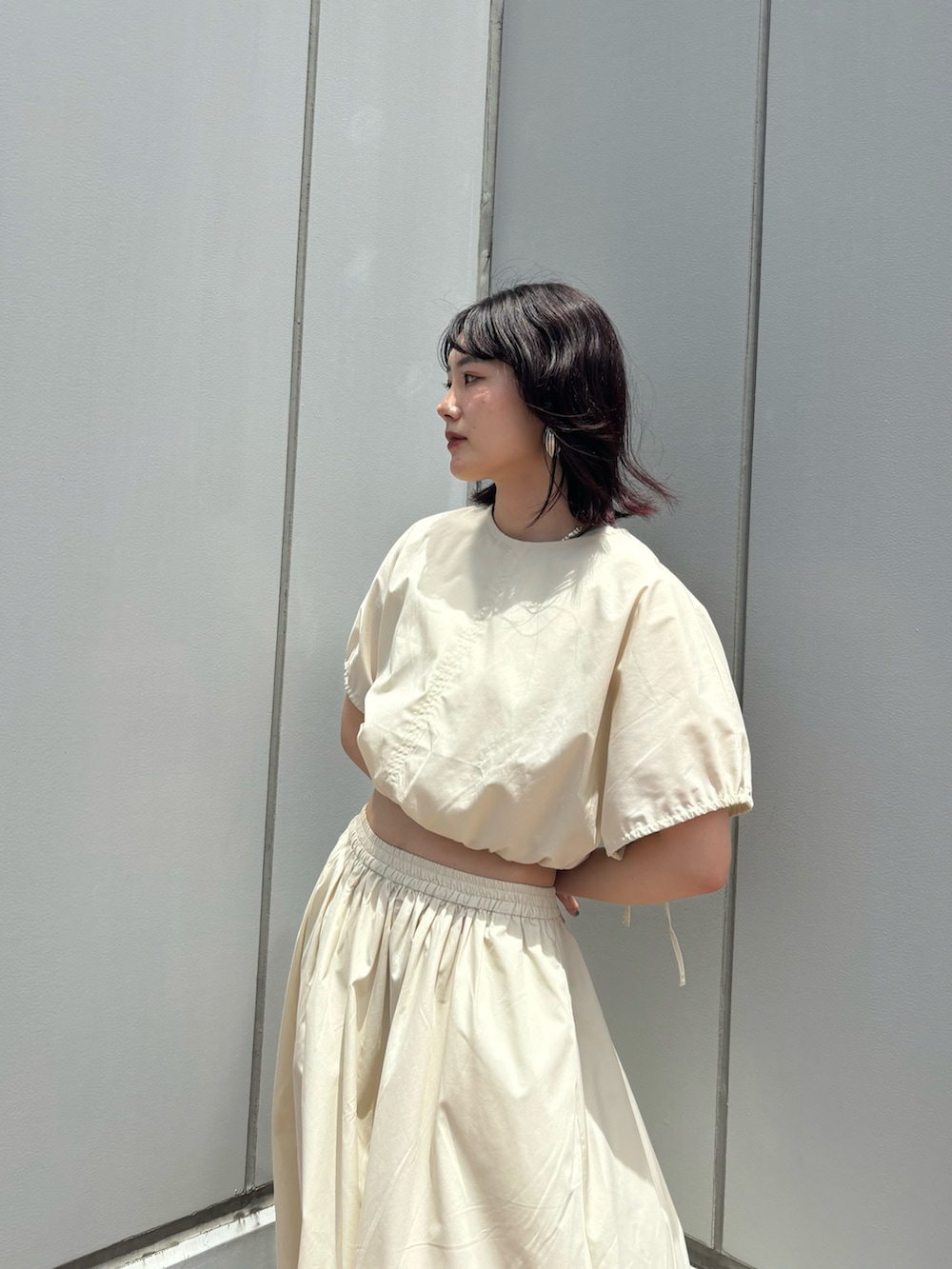 ホワイト系のワンピース、ホワイト系のスニーカーを着用したレディースの夏コーディネートの2枚目の写真