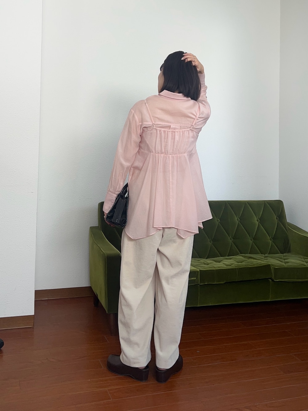 ピンク系のシャツ/ブラウス、ブラック系のボストンバッグを着用したレディースの春コーディネートの2枚目の写真