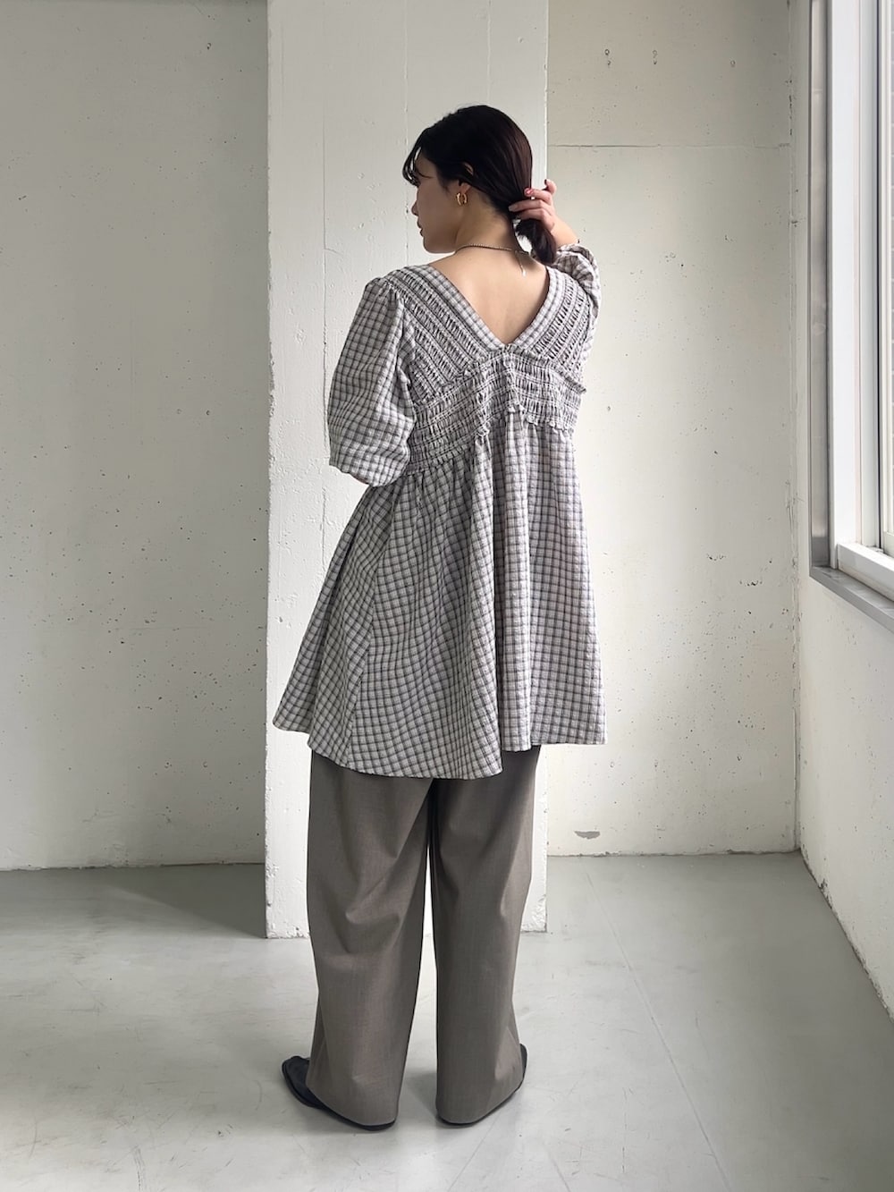 ベージュ系のワンピース、ブラック系のハンドバッグ、グレー系のその他パンツを着用したレディースの春コーディネートの2枚目の写真