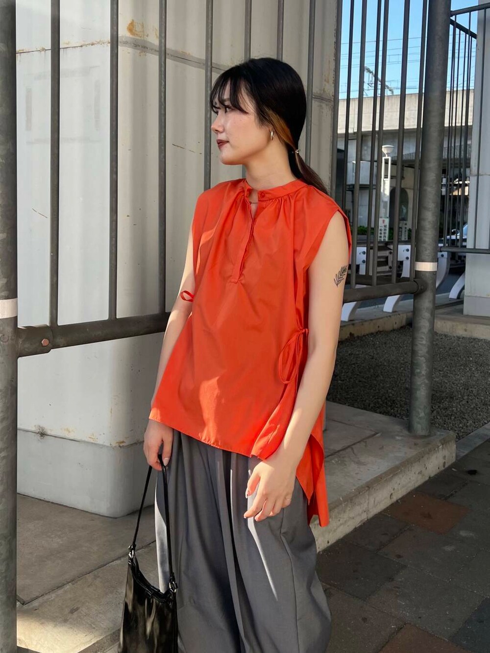 グレー系のその他パンツ、ブラック系のショルダーバッグ、ブラック系のサンダルを着用したレディースの春コーディネートの2枚目の写真