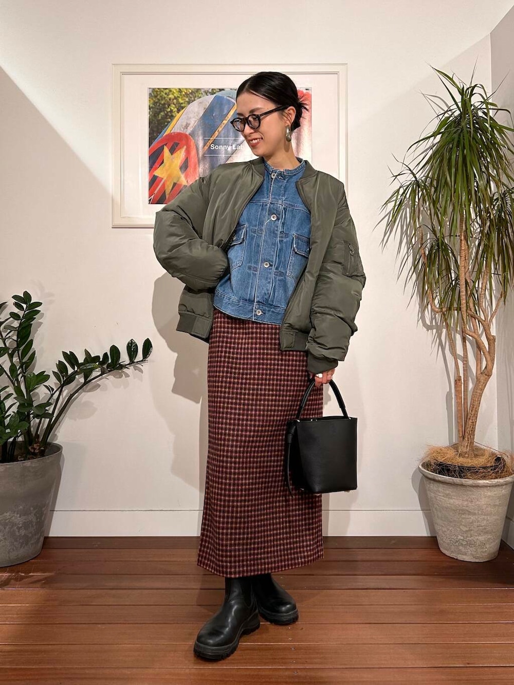 ブラック系のショルダーバッグ、ブルー系のデニムジャケット、グリーン系のMA-1を着用したレディースの秋コーディネートの3枚目の写真