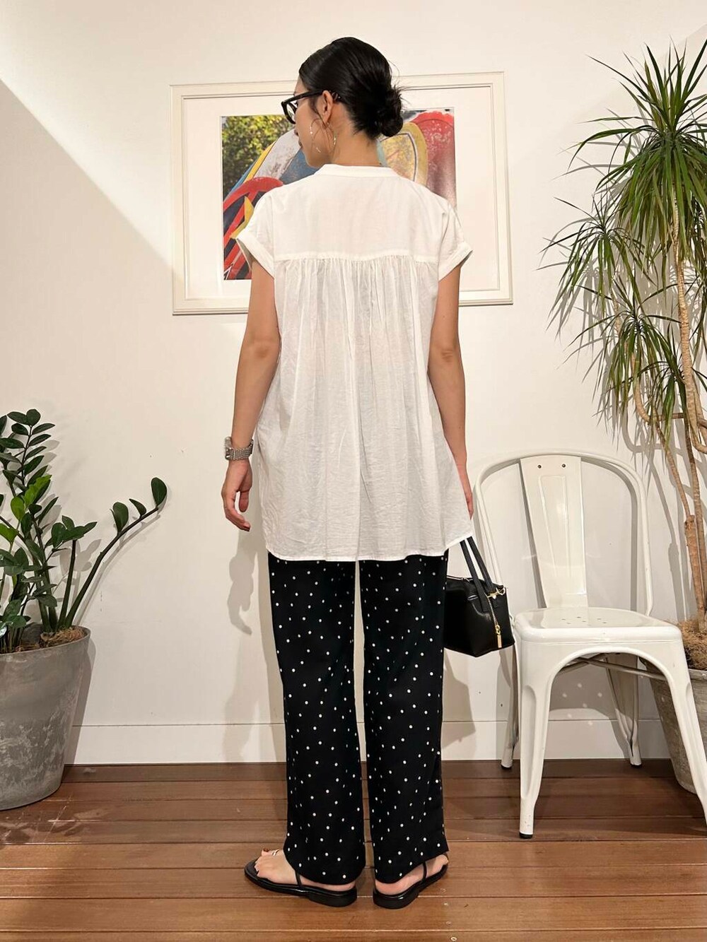 ブラック系のハンドバッグ、ブラック系のその他パンツ、ホワイト系のTシャツ/カットソーを着用したレディースの夏コーディネートの3枚目の写真