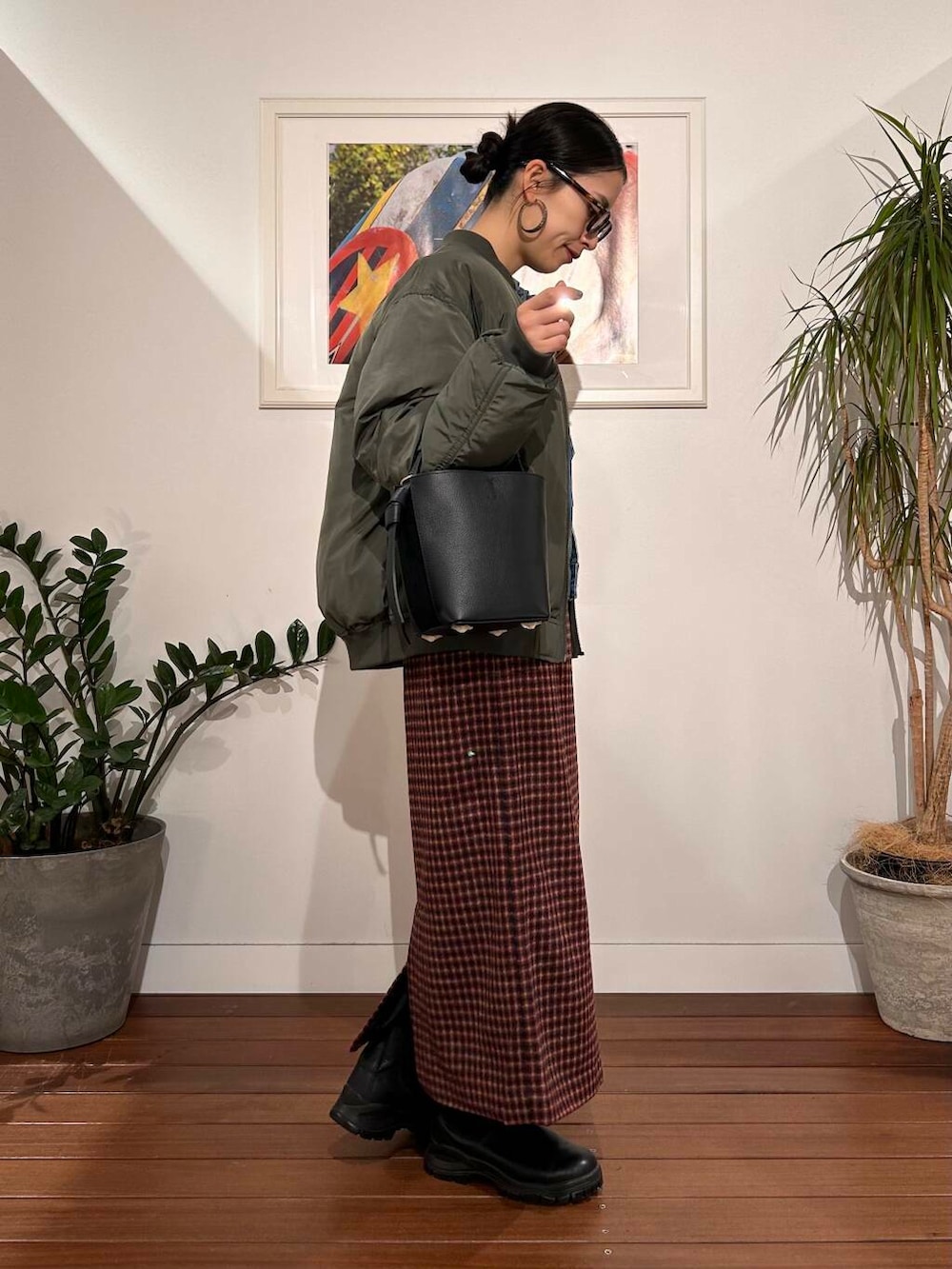 ブラック系のショルダーバッグ、ブルー系のデニムジャケット、グリーン系のMA-1を着用したレディースの秋コーディネートの5枚目の写真