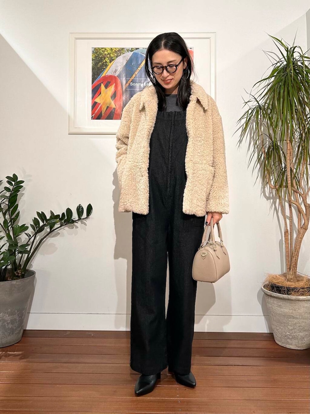 ブラック系のサロペット/オーバーオール、ホワイト系のブルゾン、ベージュ系のボストンバッグを着用したレディースの秋コーディネートの5枚目の写真