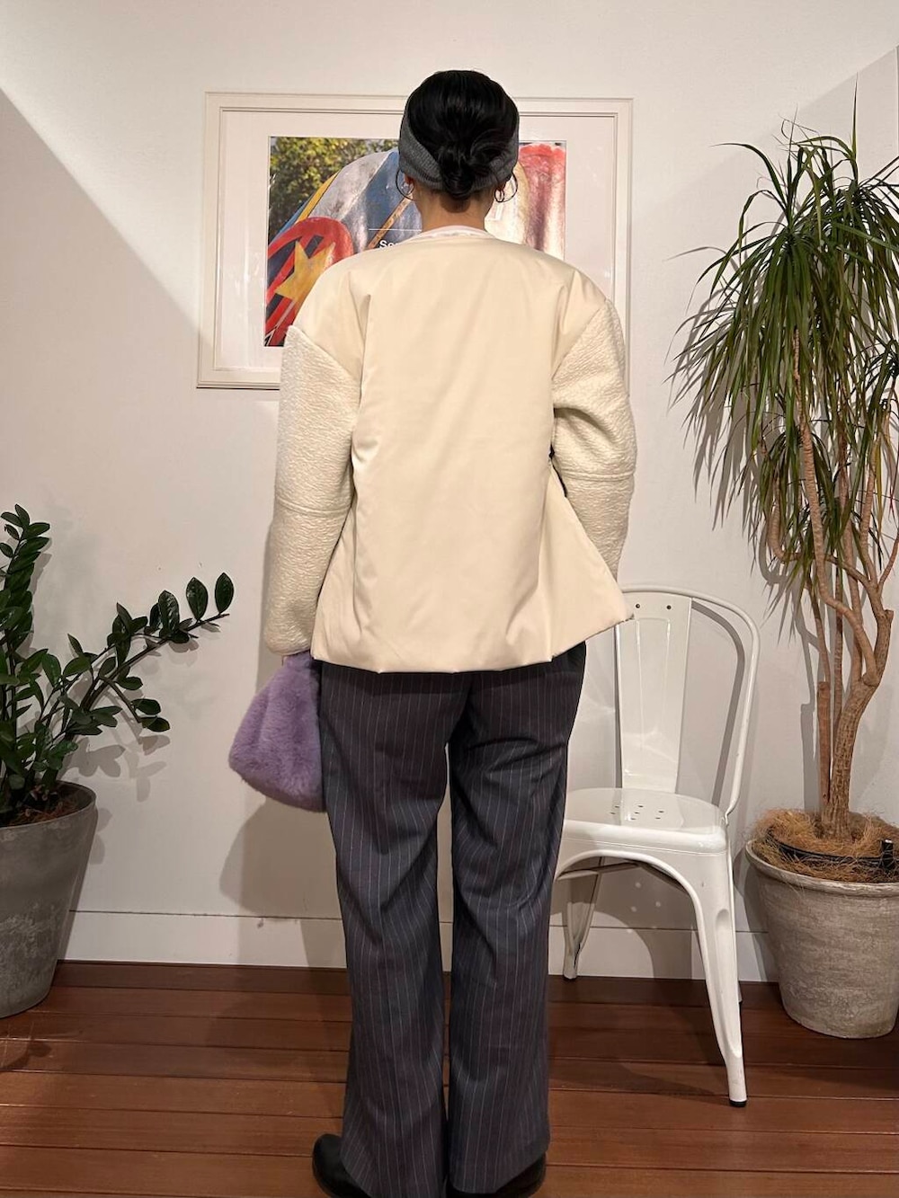 パープル系のハンドバッグ、ホワイト系のブルゾン、グレー系のサロペット/オーバーオールを着用したレディースの冬コーディネートの3枚目の写真