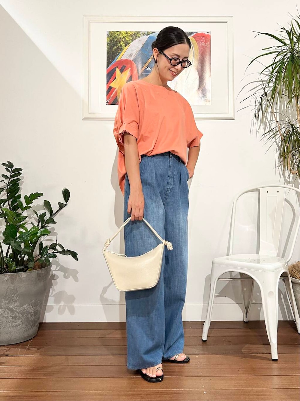 ホワイト系のショルダーバッグ、オレンジ系のTシャツ/カットソー、ブルー系のデニムパンツを着用したレディースの夏コーディネートの4枚目の写真