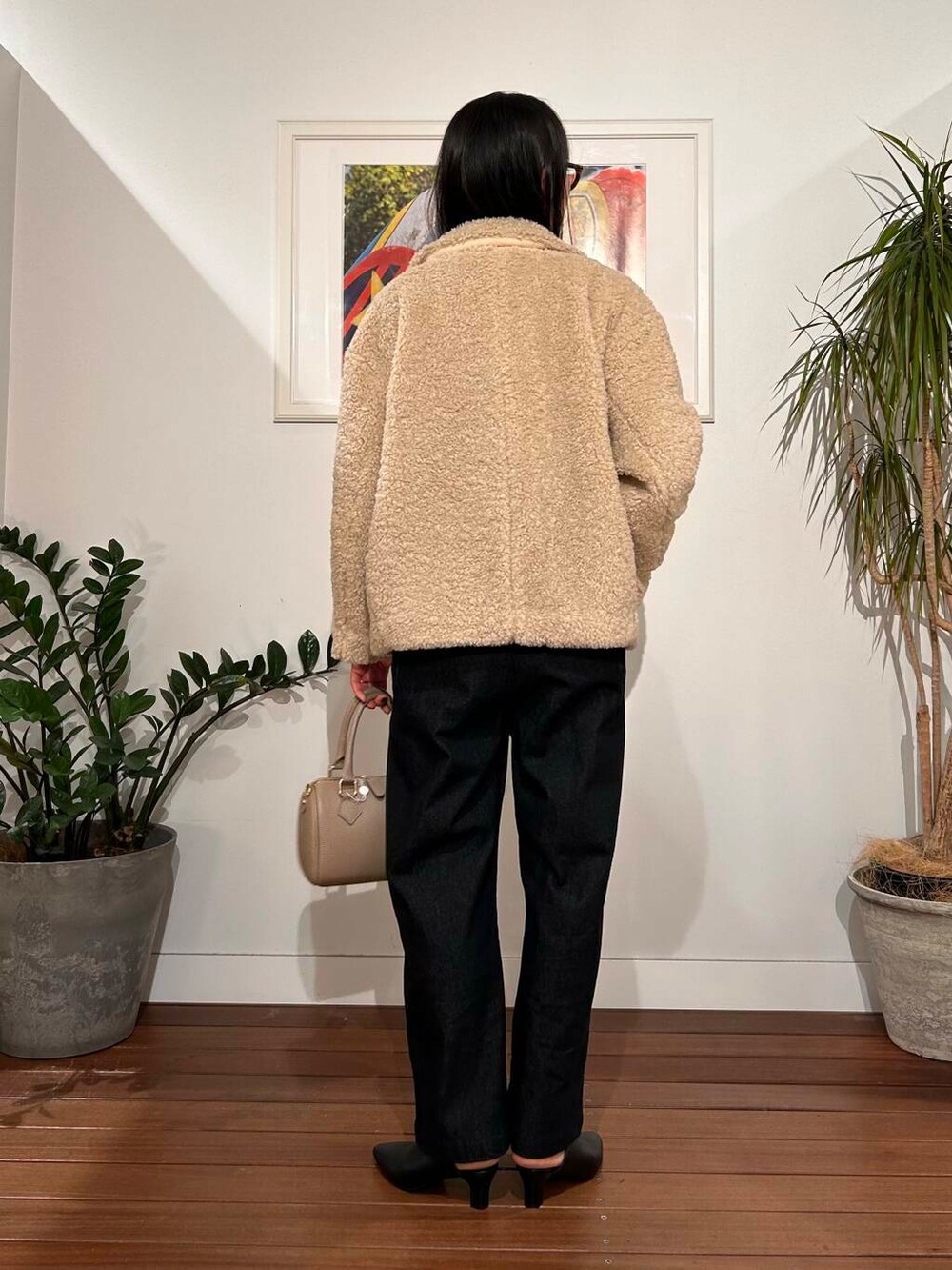 ブラック系のサロペット/オーバーオール、ホワイト系のブルゾン、ベージュ系のボストンバッグを着用したレディースの秋コーディネートの4枚目の写真