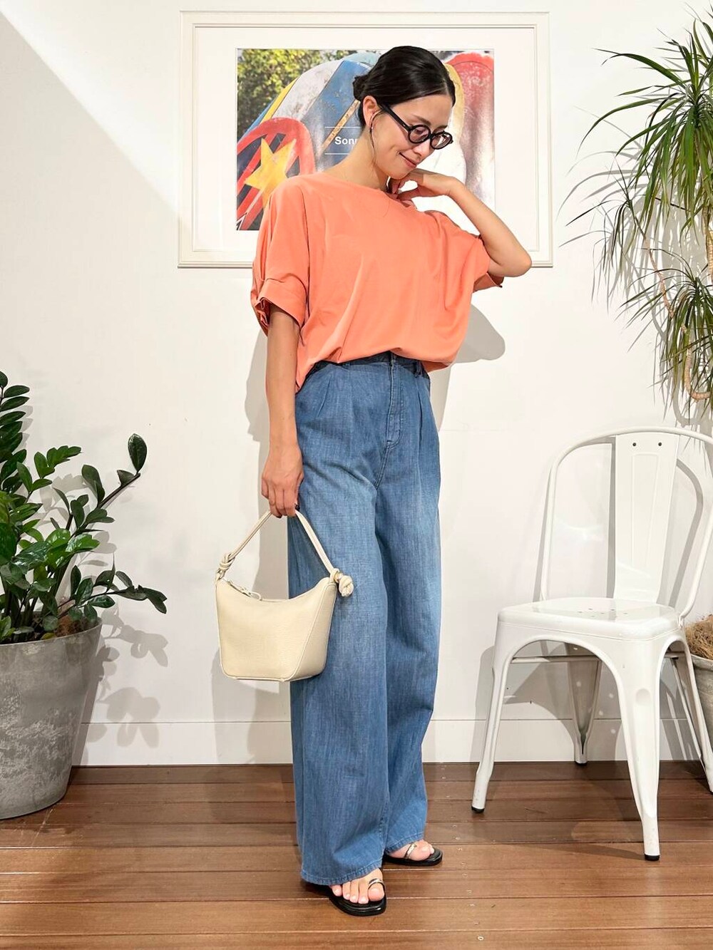 ホワイト系のショルダーバッグ、オレンジ系のTシャツ/カットソー、ブルー系のデニムパンツを着用したレディースの夏コーディネートの5枚目の写真