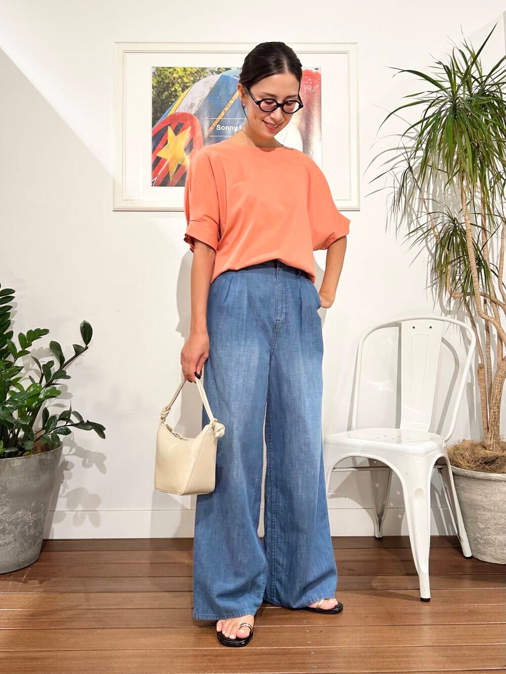ホワイト系のショルダーバッグ、オレンジ系のTシャツ/カットソー、ブルー系のデニムパンツを着用したレディースの夏コーディネートの6枚目の写真