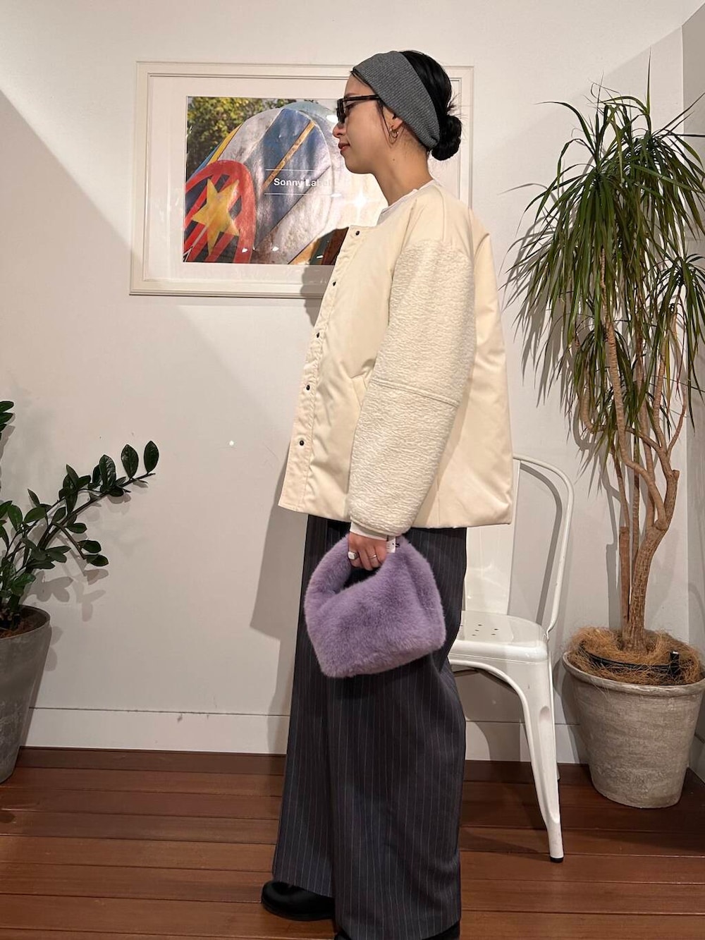 パープル系のハンドバッグ、ホワイト系のブルゾン、グレー系のサロペット/オーバーオールを着用したレディースの冬コーディネートの2枚目の写真