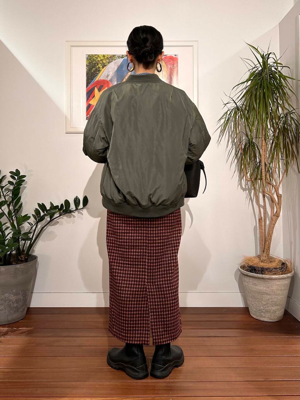 ブラック系のショルダーバッグ、ブルー系のデニムジャケット、グリーン系のMA-1を着用したレディースの秋コーディネートの4枚目の写真