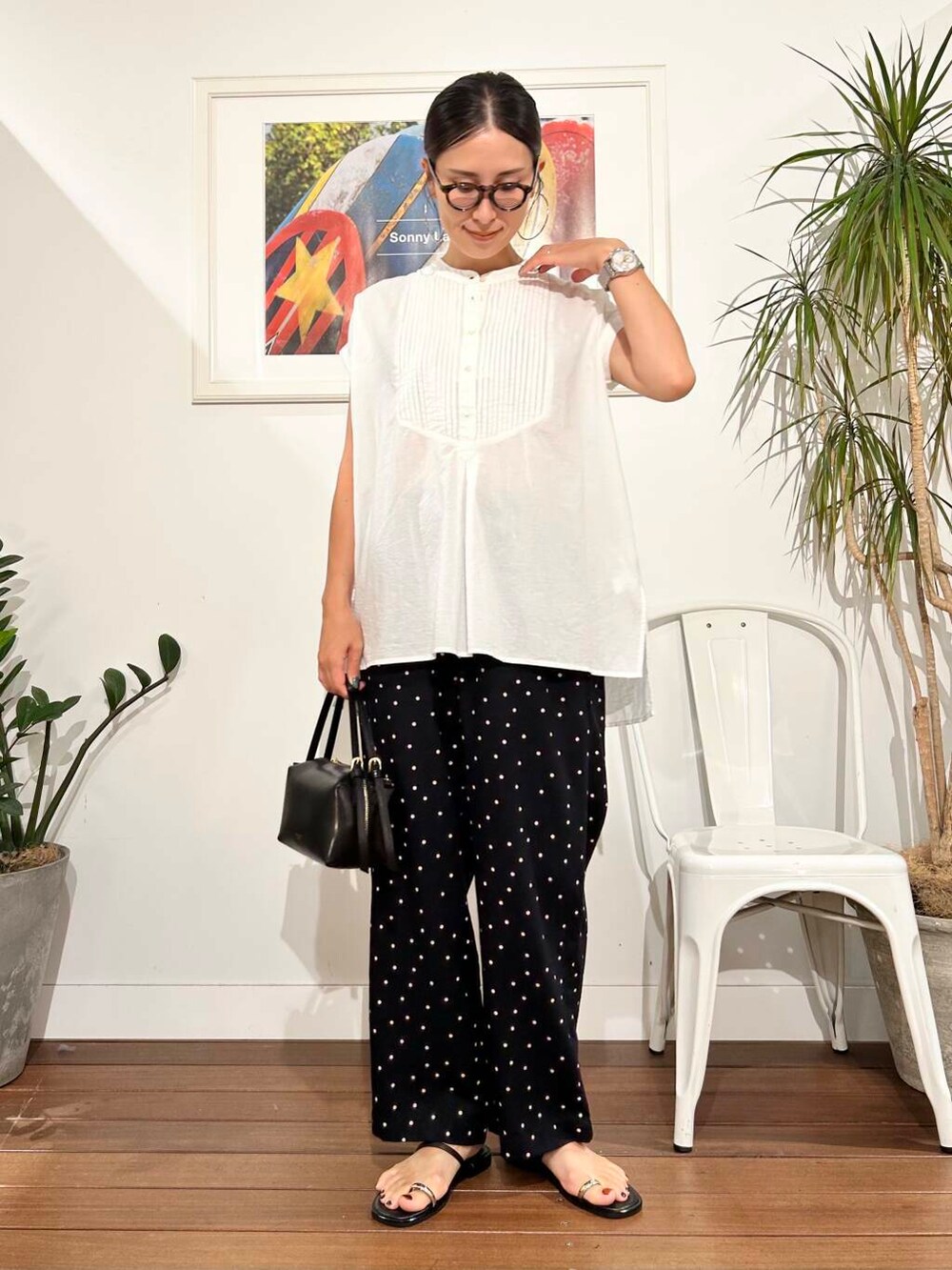 ブラック系のハンドバッグ、ブラック系のその他パンツ、ホワイト系のTシャツ/カットソーを着用したレディースの夏コーディネートの5枚目の写真