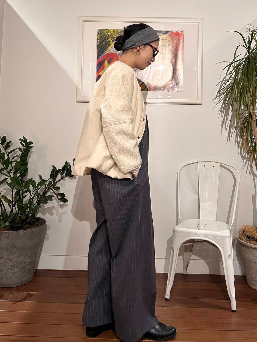 パープル系のハンドバッグ、ホワイト系のブルゾン、グレー系のサロペット/オーバーオールを着用したレディースの冬コーディネートの4枚目の写真