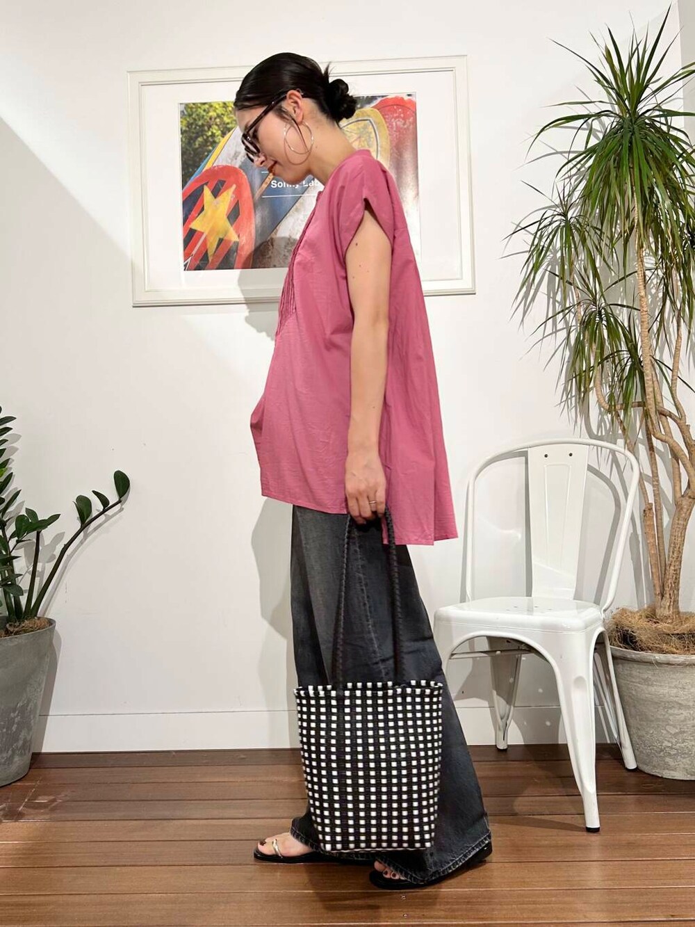 ブラック系のデニムパンツ、ピンク系のTシャツ/カットソー、ブラック系のトートバッグを着用したレディースの夏コーディネートの3枚目の写真