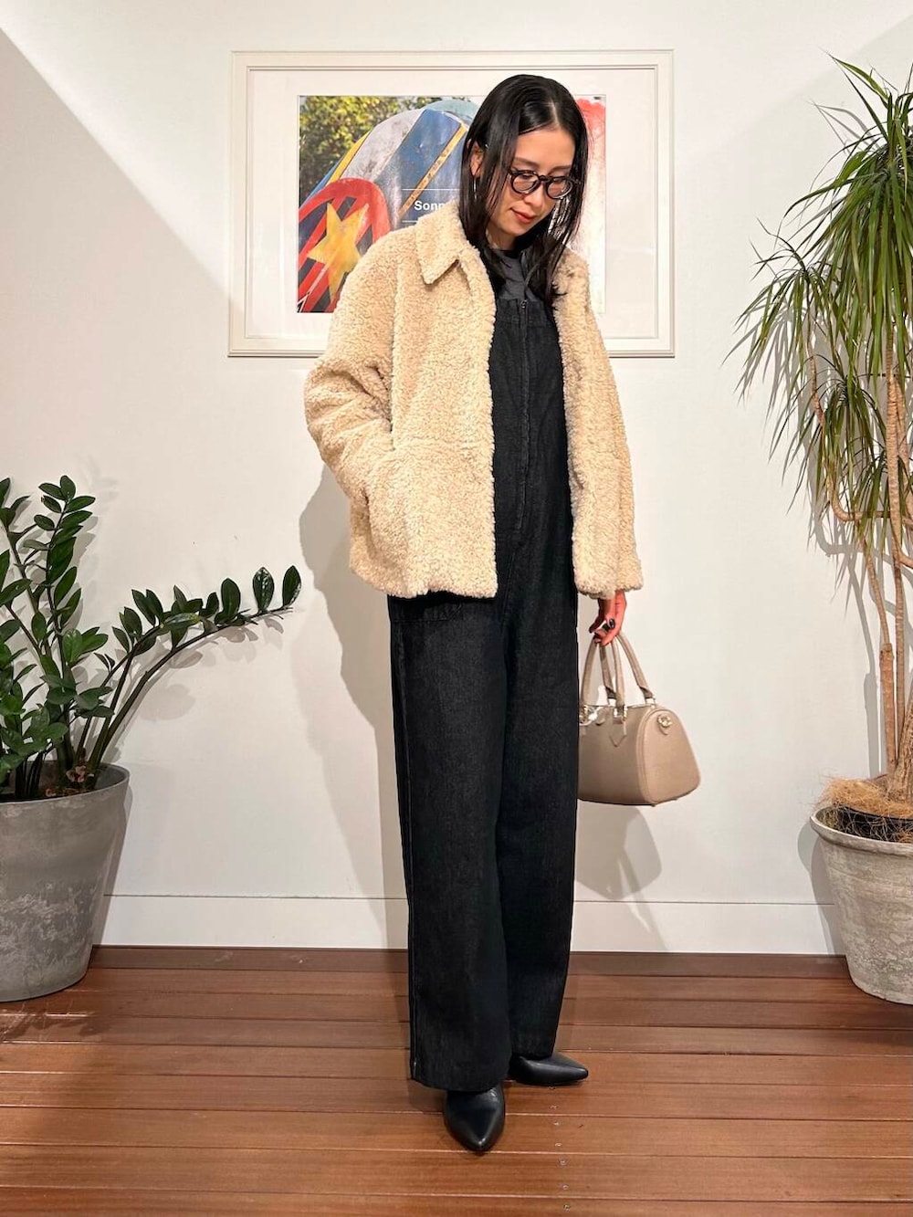 ブラック系のサロペット/オーバーオール、ホワイト系のブルゾン、ベージュ系のボストンバッグを着用したレディースの秋コーディネートの2枚目の写真