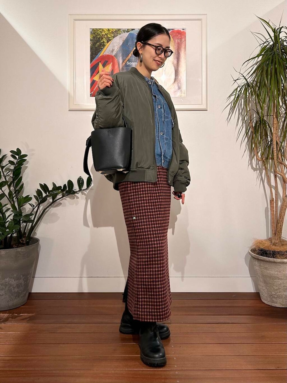 ブラック系のショルダーバッグ、ブルー系のデニムジャケット、グリーン系のMA-1を着用したレディースの秋コーディネートの2枚目の写真