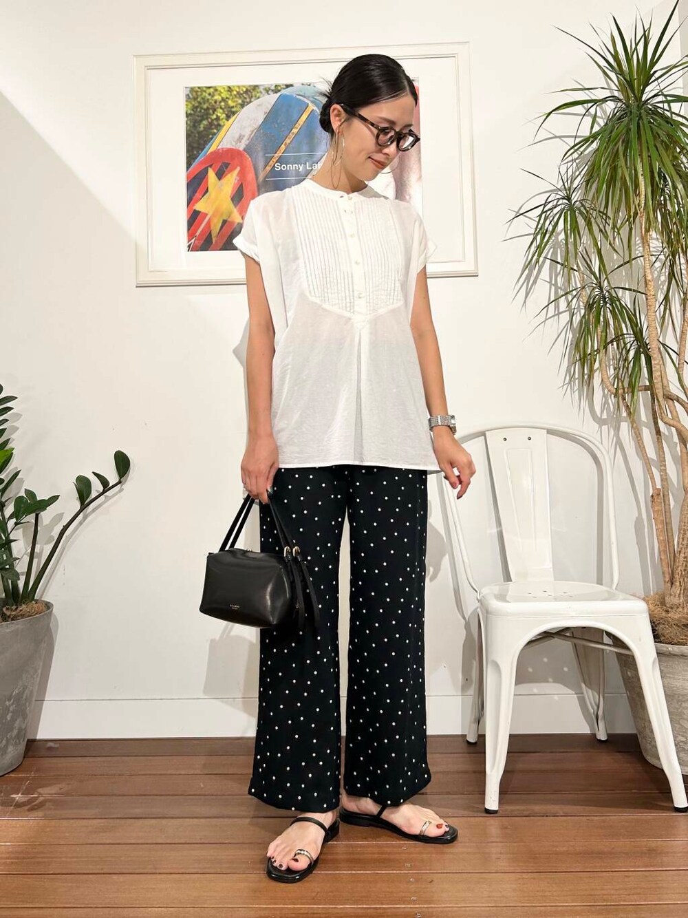 ブラック系のハンドバッグ、ブラック系のその他パンツ、ホワイト系のTシャツ/カットソーを着用したレディースの夏コーディネートの2枚目の写真
