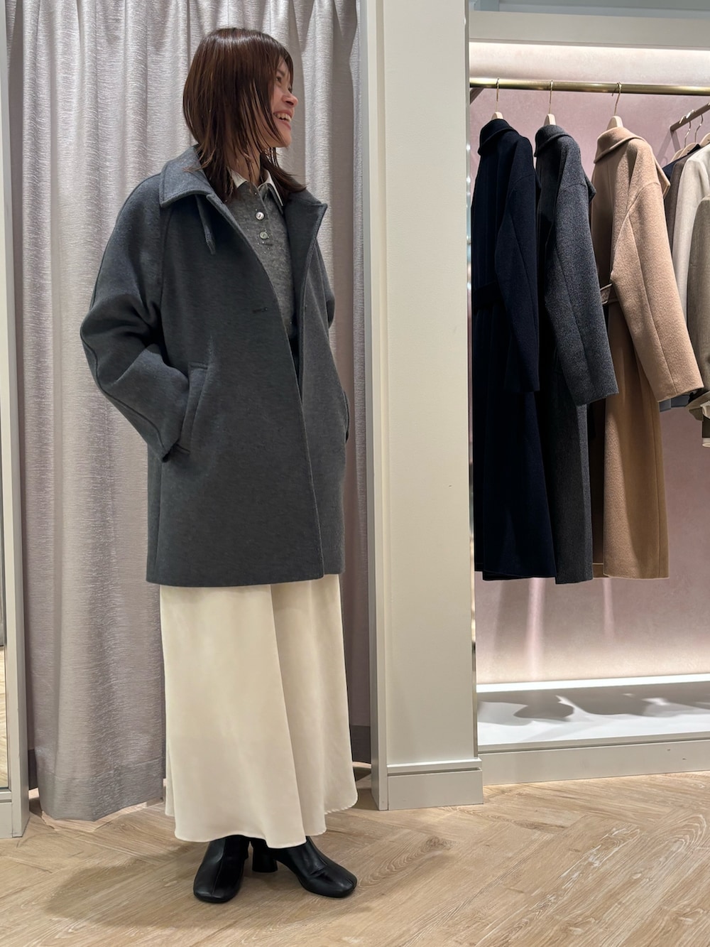 ホワイト系のスカート、グレー系のニット/セーター、ホワイト系のシャツ/ブラウスを着用したレディースの秋コーディネートの3枚目の写真