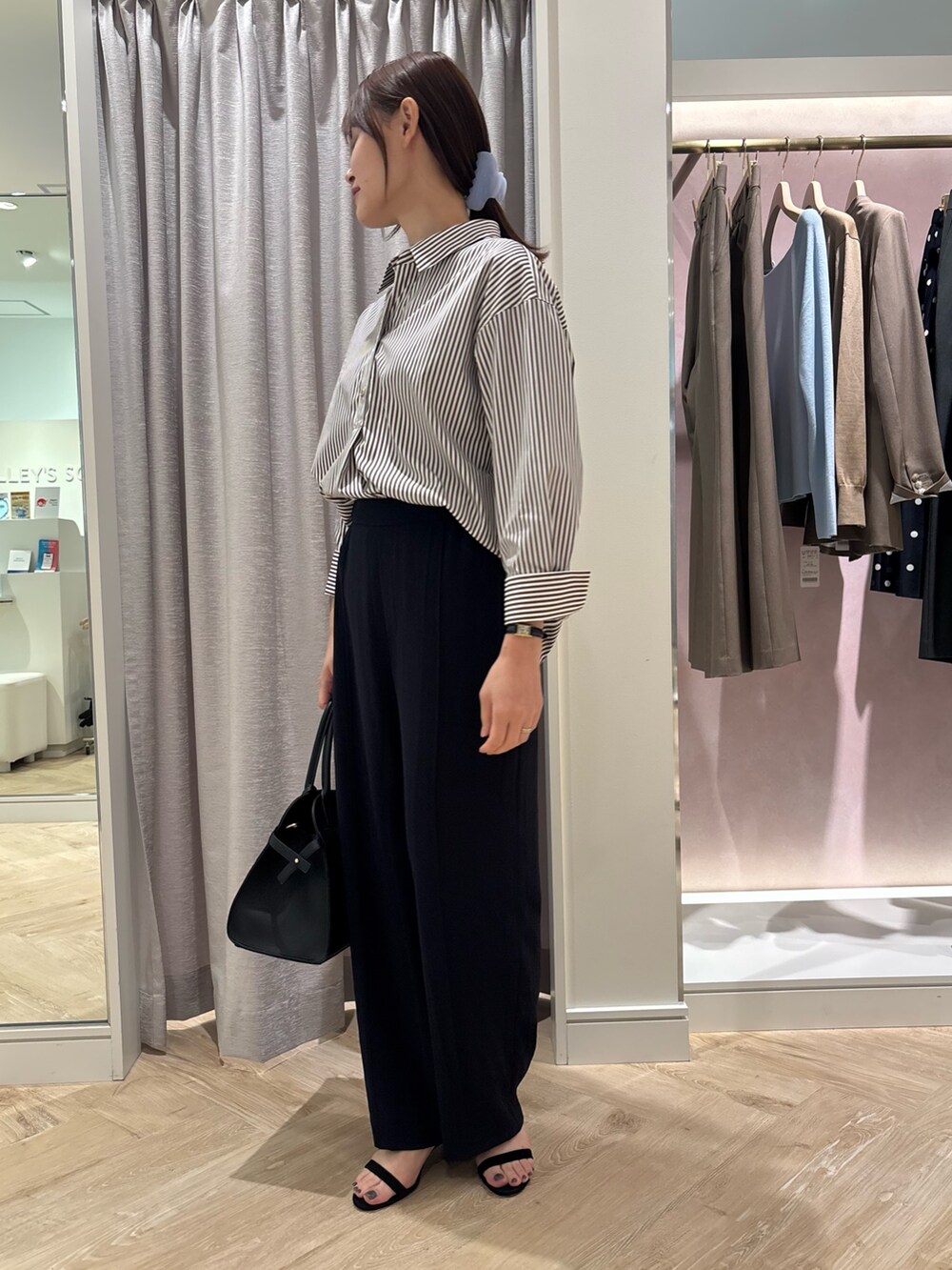 ブルー系のその他パンツ、ブラウン系のシャツ/ブラウス、ブラック系のショルダーバッグを着用したレディースの秋コーディネートの4枚目の写真