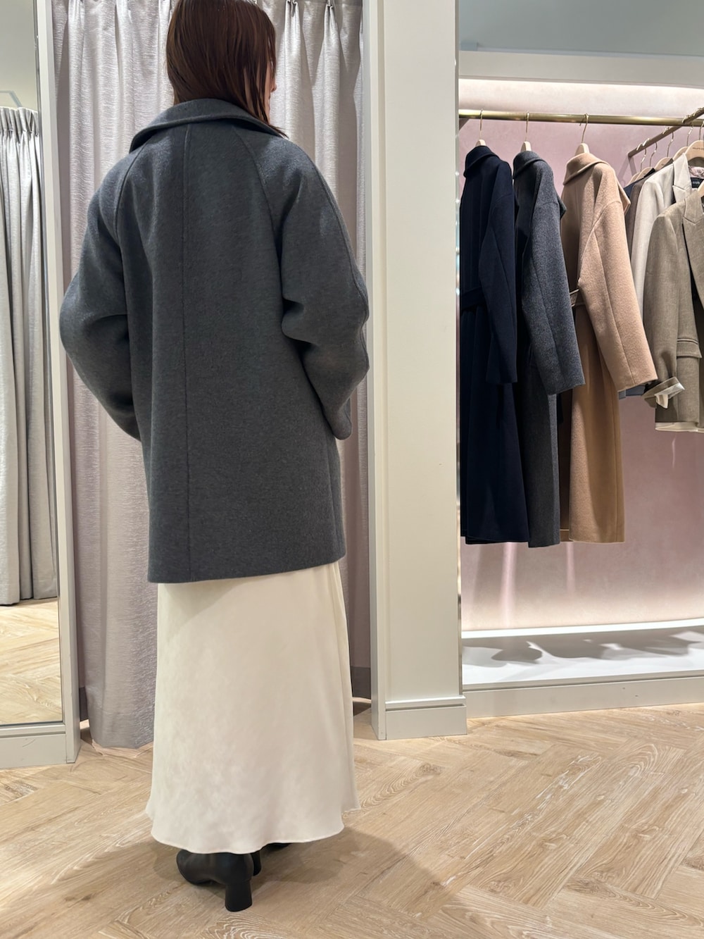 ホワイト系のスカート、グレー系のニット/セーター、ホワイト系のシャツ/ブラウスを着用したレディースの秋コーディネートの4枚目の写真