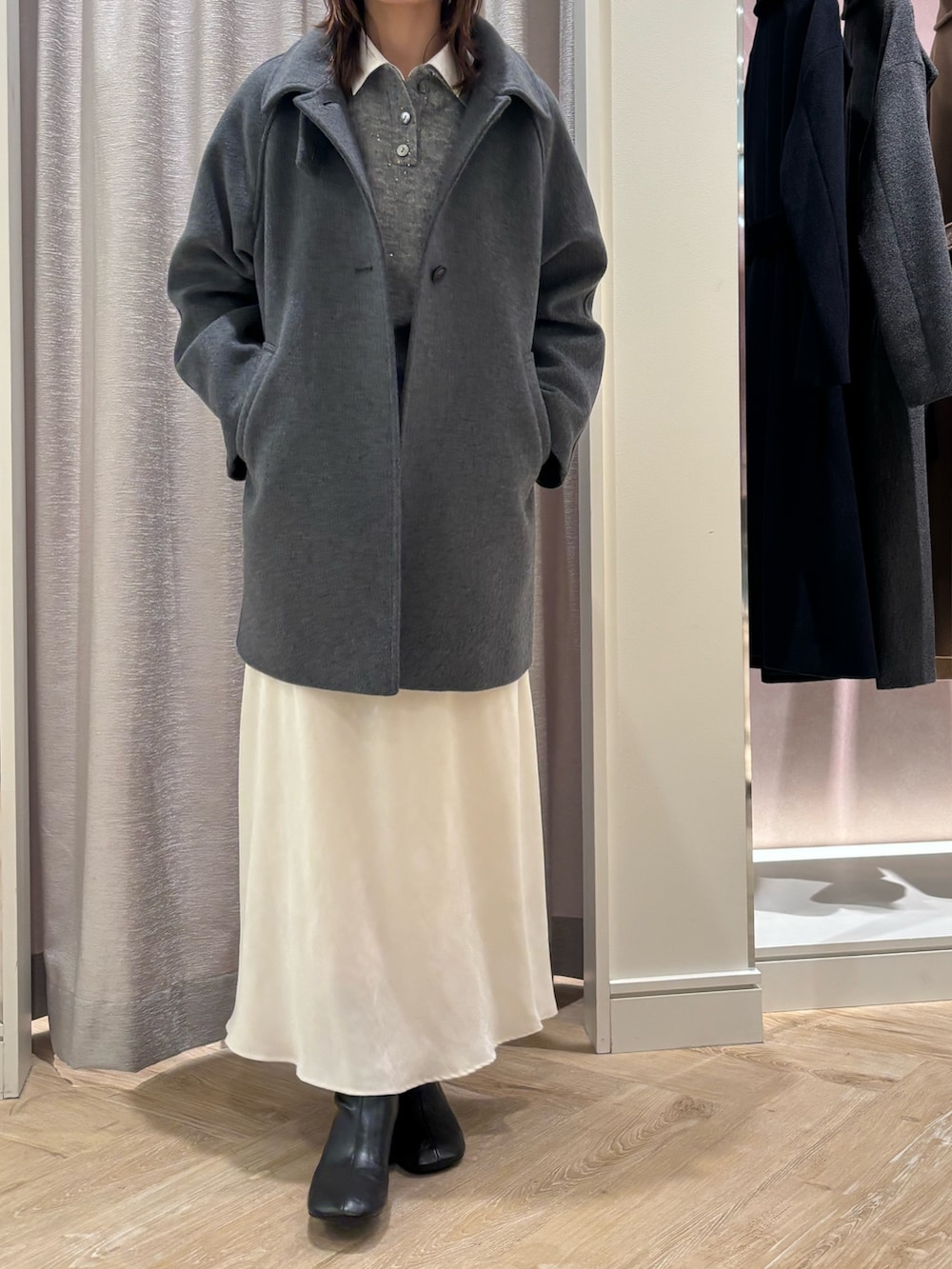 ホワイト系のスカート、グレー系のニット/セーター、ホワイト系のシャツ/ブラウスを着用したレディースの秋コーディネートの2枚目の写真