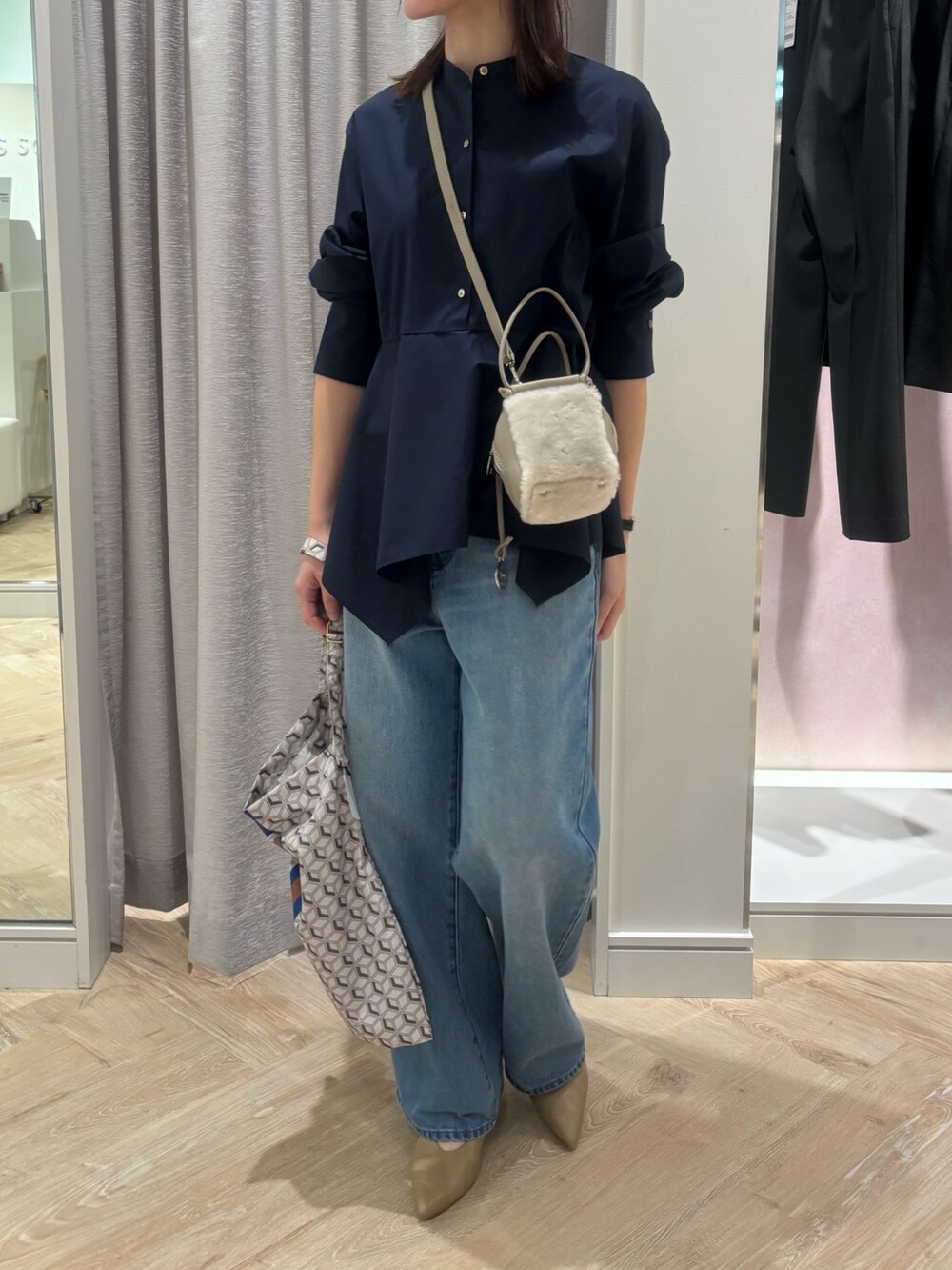 ブルー系のデニムパンツ、ブルー系のショルダーバッグ、ブルー系のシャツ/ブラウスを着用したレディースの秋コーディネートの2枚目の写真