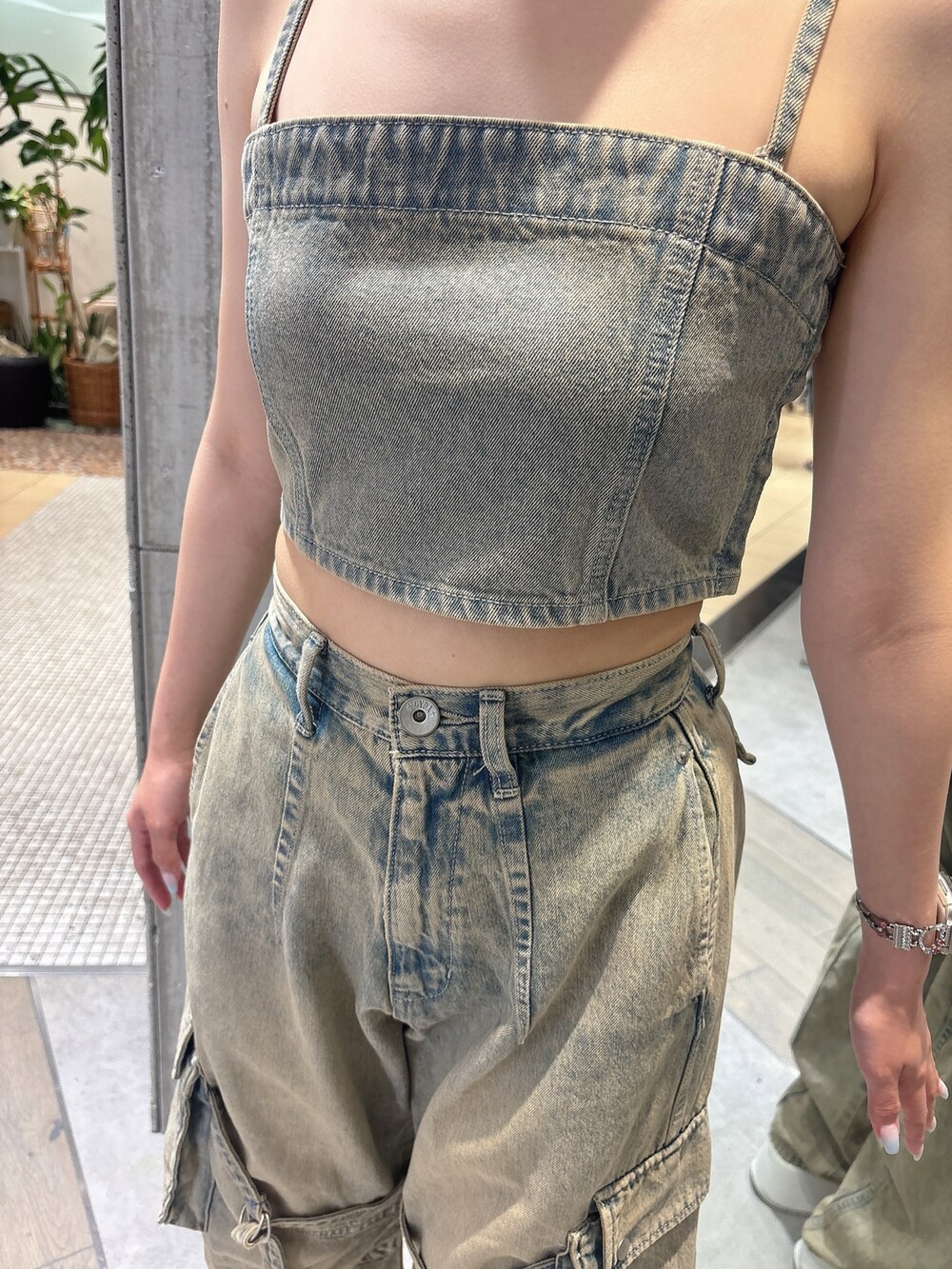 ブルー系のデニムパンツ、ブルー系のキャミソール、ホワイト系のサンダルを着用したレディースの夏コーディネートの6枚目の写真