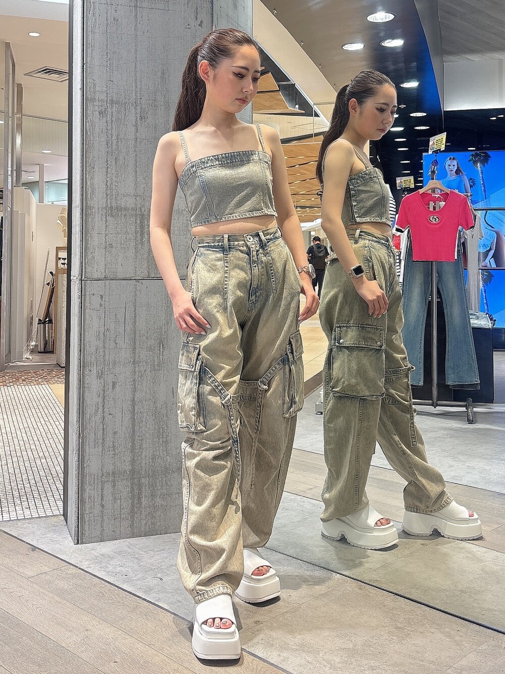 ブルー系のデニムパンツ、ブルー系のキャミソール、ホワイト系のサンダルを着用したレディースの夏コーディネートの2枚目の写真